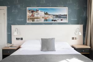 1 dormitorio con 1 cama y una foto en la pared en Ship and Castle Hotel, en Saint Mawes