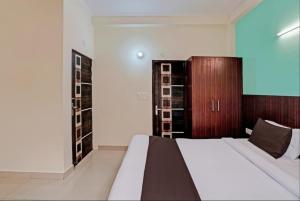 1 dormitorio con 1 cama y armario de madera en Hotel Imperial, en Greater Noida