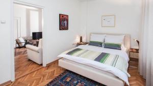 a white bedroom with a large bed and a couch at Apartment Balkan in Belgrade