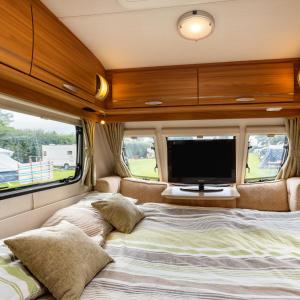 a bedroom in an rv with a bed and a tv at Luxury Luna in Whitchurch