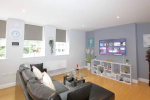 a living room with a couch and a table at Gorgeous 2 Bed 2 Bath Flat and Parking by CozyNest in Reading