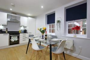 a kitchen with a dining room table and chairs at Gorgeous 2 Bed 2 Bath Flat and Parking by CozyNest in Reading