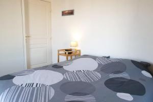 a bedroom with a bed with a black and white comforter at Le Castel d'Orne - Piscine et Terrasse in Caen