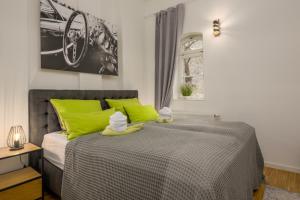 a bedroom with a bed with lime green pillows and towels at SweetHome - Luxus pur - große Küche, Terrasse, Stellplatz, WiFi in Halle an der Saale