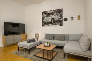 a living room with a couch and a table and a tv at SweetHome - Luxus pur - große Küche, Terrasse, Stellplatz, WiFi in Halle an der Saale