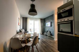 a kitchen and living room with a table and chairs at Old School Apartament in Bolesławiec