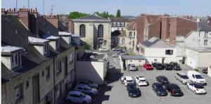 una calle de la ciudad con coches aparcados en un estacionamiento en L'escapade de Compiègne centre charmant, en Compiègne