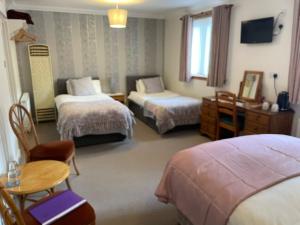 Elderslie Guest House في أوبان: غرفة فندقية بسريرين وطاولة وكراسي