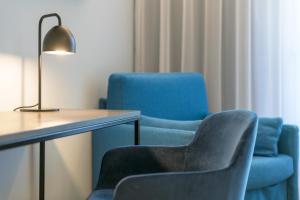 2 blaue Stühle und ein Tisch mit einer Lampe in der Unterkunft Regina del Garda Suite in Toscolano-Maderno