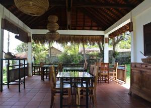 a dining room with tables and chairs on a patio at Sabbay Kep in Kep