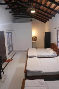 a bedroom with three beds in a room at HULSE HOMESTAY in Kalasa