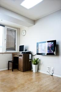 a room with a tv on a wall with a desk at Myeongdong Ecohouse in Seoul