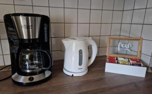 une cafetière et une cafetière sur un comptoir dans l'établissement Ruhrpottbude - Private Ferienwohnung im Herzen des Ruhrgebiets, à Bochum