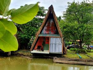 a small house in the middle of a body of water at บ้านนกฮูก อิงธารา in Ban Khlong Sai