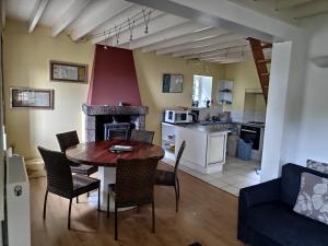 a kitchen and living room with a table and chairs at Moulin à Blé in Urville-Nacqueville