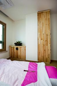 - une chambre avec un lit et une porte en bois dans l'établissement Myeongdong Ecohouse, à Séoul