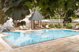 a swimming pool with a gazebo in a yard at Hotel Bismarck in Bad Hofgastein