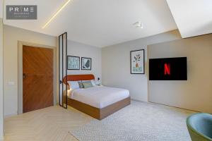 Prime Residence Sheikh Zayed في Sheikh Zayed: غرفة نوم مع سرير مزدوج كبير وتلفزيون