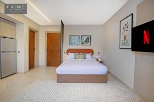 1 dormitorio con 1 cama y TV. en Prime Residence Sheikh Zayed, en Sheikh Zayed