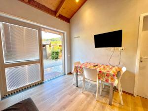 a dining room with a table with chairs and a television at Villaggio Camping Valdeiva in Deiva Marina