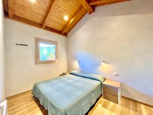 a small bedroom with a bed and a window at Villaggio Camping Valdeiva in Deiva Marina