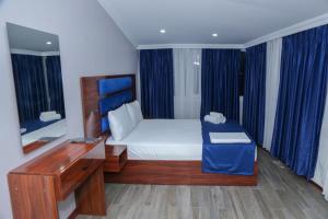 a bedroom with a bed with a desk and a mirror at Lion King Hotel in Esenyurt