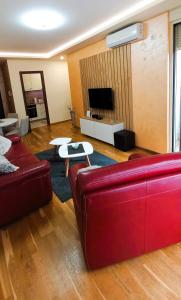 - un salon avec un canapé rouge et une table dans l'établissement Budva Morska oaza, à Budva