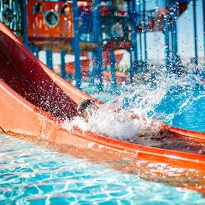 a child sliding down a water slide in a pool at ENTRE VENTOUX ET LUBERON Chambre d'hôte in Sault-de-Vaucluse