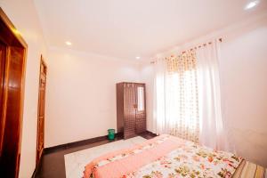 a bedroom with a bed and a large window at The Palaixon in Bujumbura