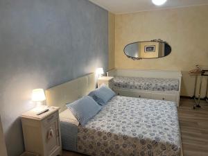 a small bedroom with a bed and a mirror at Dimora Del Riccio in Bergamo