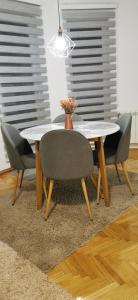 una mesa de comedor con sillas y un jarrón. en Apartman Paradiso BN 1, en Bijeljina