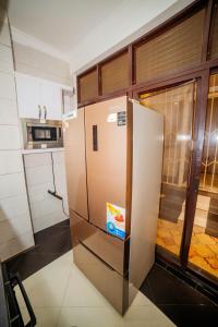 a stainless steel refrigerator in a kitchen with a window at The Palaixon in Bujumbura
