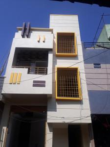 un edificio blanco alto con ventanas amarillas. en Janaki Nilaya, en Belgaum