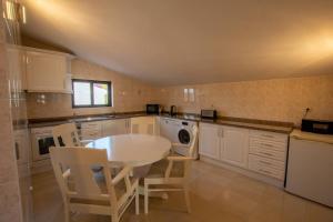a kitchen with a white table and white chairs at A House With a View in Aljezur