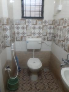 y baño con aseo y lavamanos. en Janaki Nilaya, en Belgaum