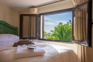 a bedroom with a bed with a large window at A House With a View in Aljezur