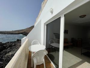 balcón con mesa, sillas y vistas al océano en Apartamento en Tamaduste con maravillosa vistas al mar en Tamaduste
