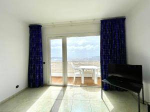 um quarto com uma varanda com uma mesa e uma janela em Apartamento en Tamaduste con maravillosa vistas al mar em Tamaduste