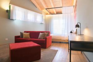 ein Wohnzimmer mit einem roten Sofa und einem Tisch in der Unterkunft Regina del Garda Suite in Toscolano-Maderno