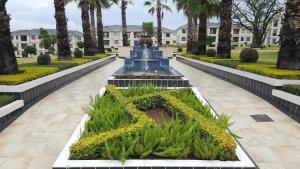 a fountain in the middle of a park with palm trees at Emerald Gem-Luxury Apartment in Sandton