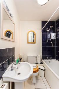 a bathroom with a sink and a toilet and a tub at Spacious 2BD House wPrivate Garden - Kennington! in London