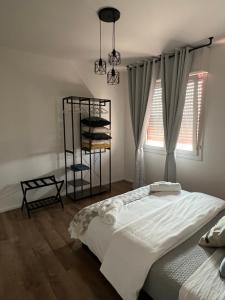 Appartamento Business Milano في ميلانو: غرفة نوم مع سرير ورف مع المناشف