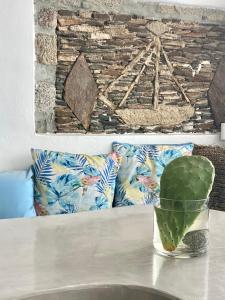 - une table avec un vase sur une table et des oreillers dans l'établissement Flaskos Suites and more, à Agios Stefanos