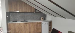 an attic kitchen with wooden cabinets and a sink at Stan na dan Luna in Pale