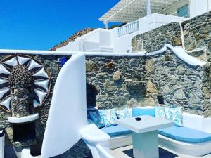 a stone wall with a bench and a table at Flaskos Suites and more in Agios Stefanos