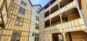 un groupe de bâtiments avec fenêtres et un bâtiment avec dans l'établissement Au charme d'antan - Un joyau caché, à Troyes