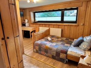 ザコパネにあるWynajem Pokoi Magdalenaの木製の部屋にベッド1台が備わるベッドルーム1室があります。