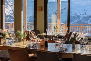 - une table avec des verres à vin dans un restaurant dans l'établissement Dormio Resort Les Portes du Grand Massif, à Flaine