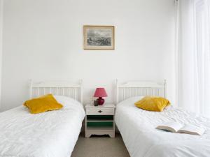 dwa łóżka siedzące obok siebie w sypialni w obiekcie Atlantique, Appartement vue mer classé 2 étoiles à Carnac Plage w mieście Carnac