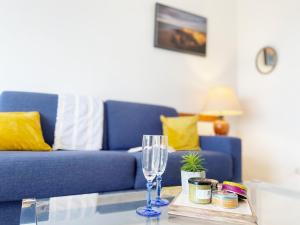 salon z niebieską kanapą i szklanym stołem w obiekcie Atlantique, Appartement vue mer classé 2 étoiles à Carnac Plage w mieście Carnac
